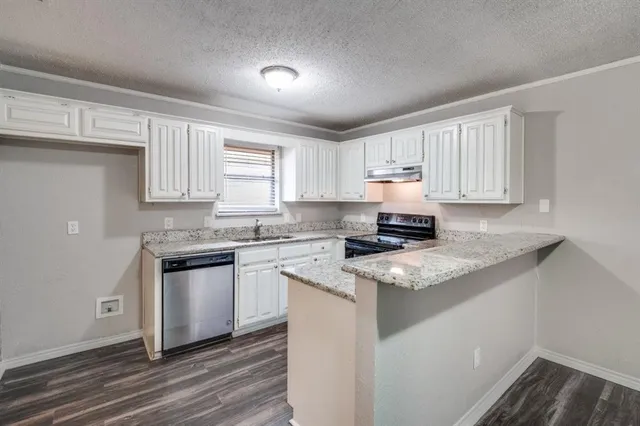 a kitchen with granite countertop cabinets stainless steel appliances and a window