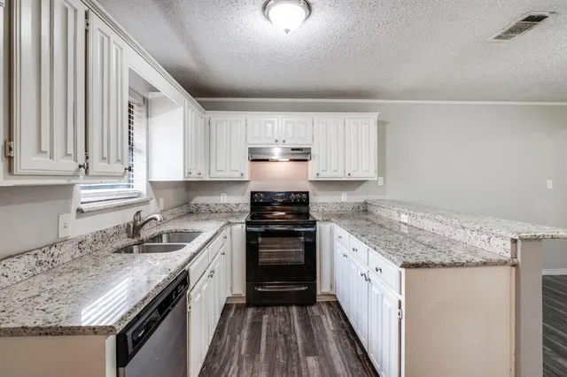 a kitchen with a sink stove and cabinets