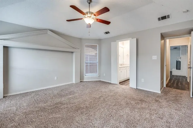 an empty room with closet and a ceiling fan