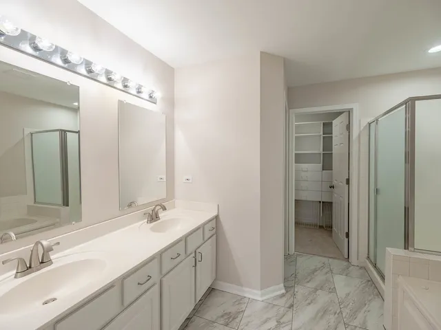 a spacious bathroom with a double vanity sink mirror and shower