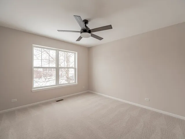 an empty room with a window and a fan