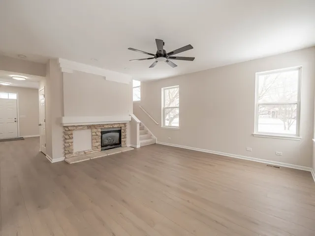 an empty room with windows and a fireplace