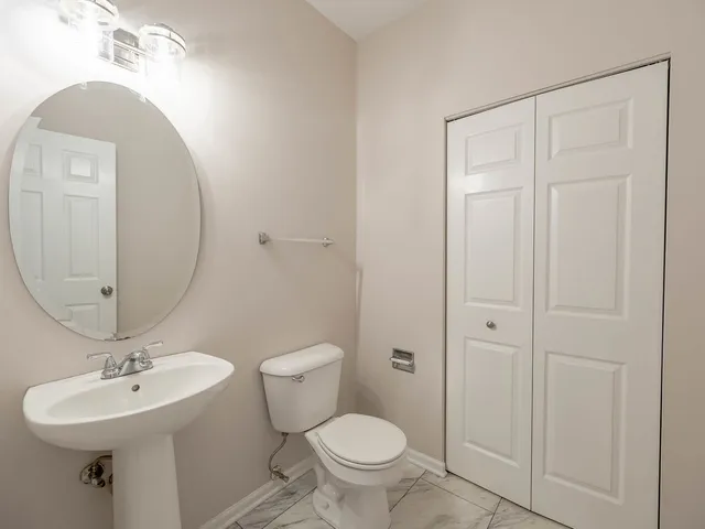 a bathroom with a toilet a sink and mirror
