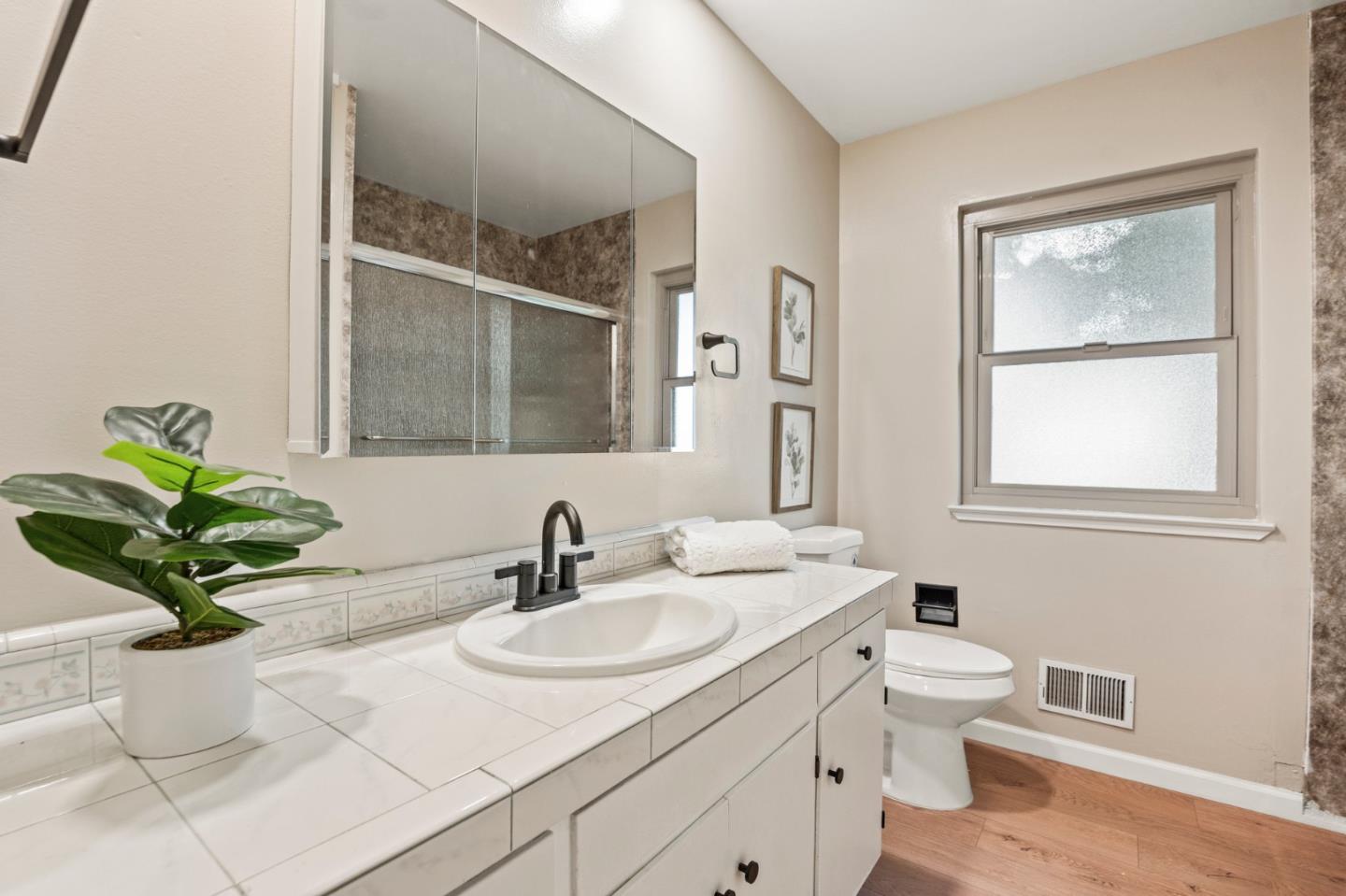 5152 Felter Road San Jose, CA 95132 - Photo 17 of 43 a bathroom with a granite countertop sink a toilet and a mirror