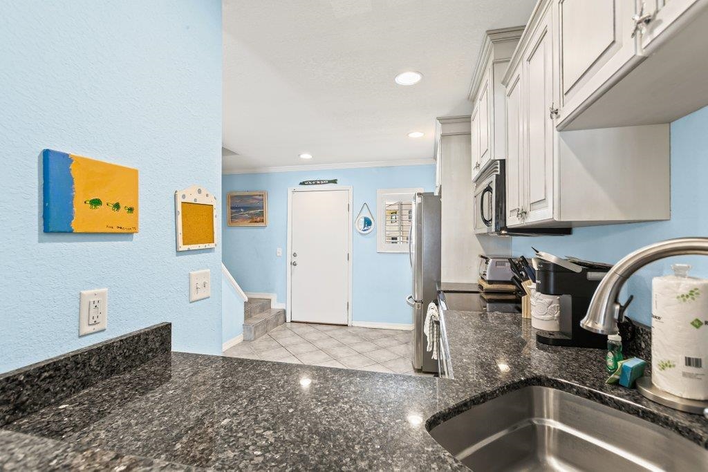 8550 A1A South, Unit 208 St. Augustine, FL 32080 - Photo 12 of 56 a kitchen with granite countertop a sink and a stove top oven