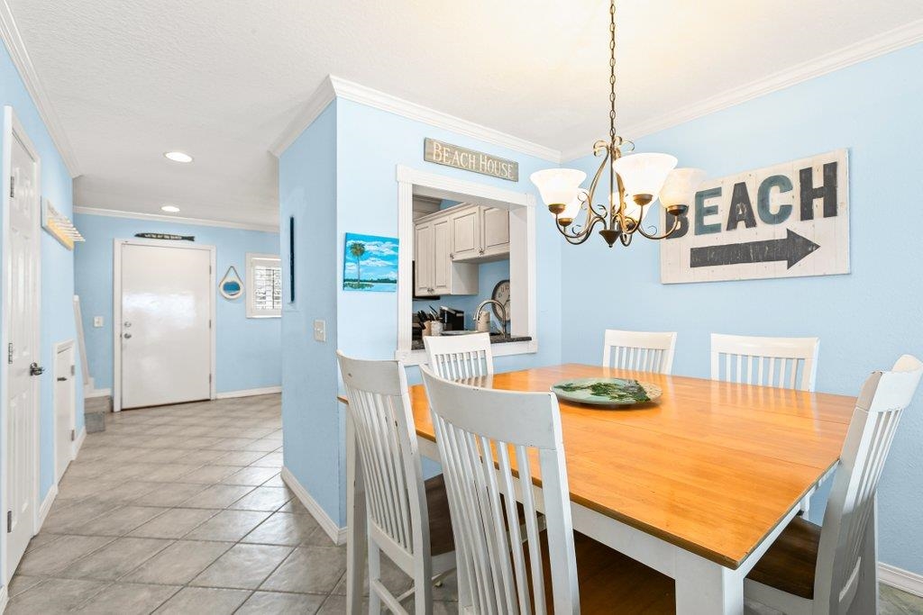 8550 A1A South, Unit 208 St. Augustine, FL 32080 - Photo 16 of 56 a view of a dining room with furniture wooden floor and chandelier
