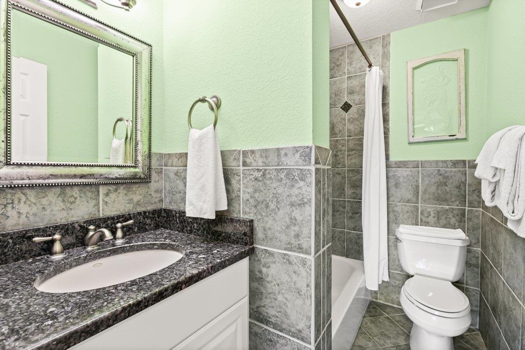 8550 A1A South, Unit 208 St. Augustine, FL 32080 - Photo 40 of 56 a bathroom with a granite countertop sink toilet and shower