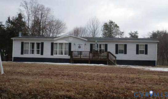 a front view of house with yard and trees in the background