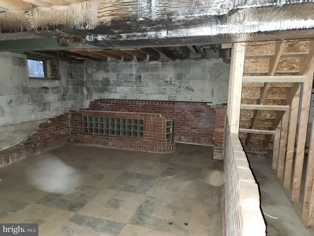 a view of an empty room with stairs and a window