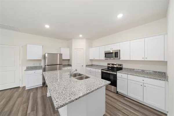 a kitchen with stainless steel appliances granite countertop a stove a sink and a refrigerator