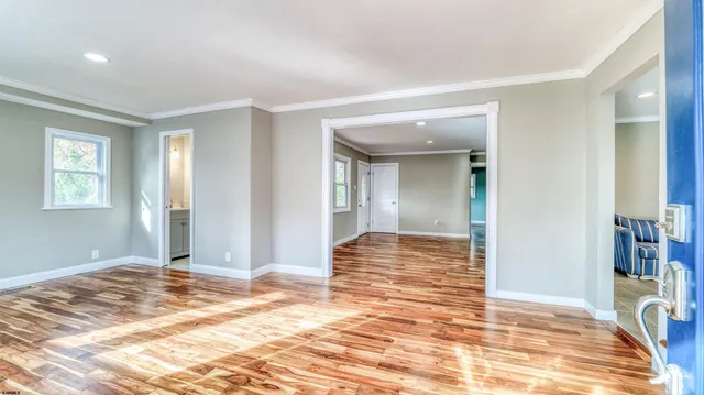 a view of a livingroom with wooden floor and a bathroom