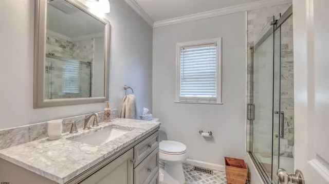 a bathroom with a granite countertop sink a toilet and a mirror