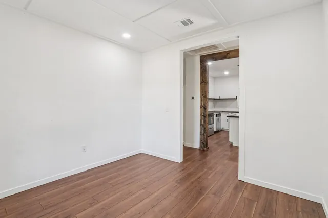 wooden floor in a hall with an empty room and wooden floor