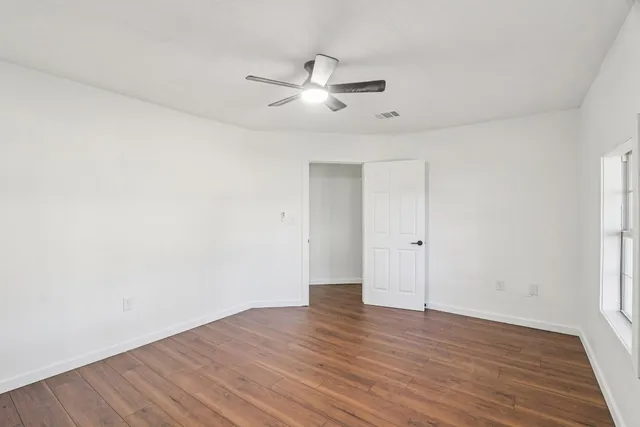 a view of an empty room with wooden floor