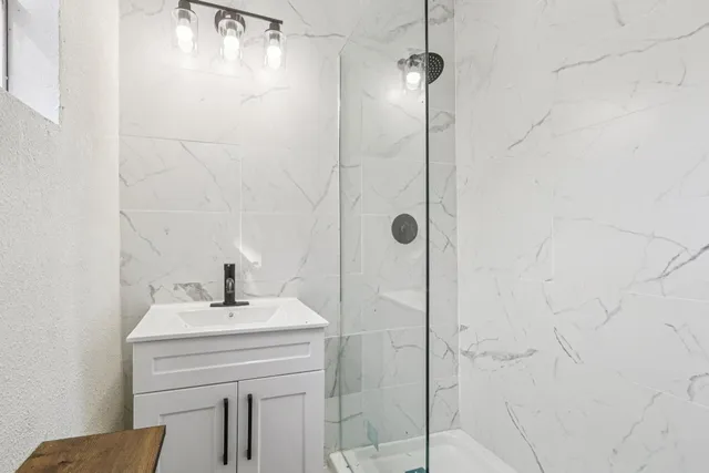 a bathroom with a sink a mirror and shower