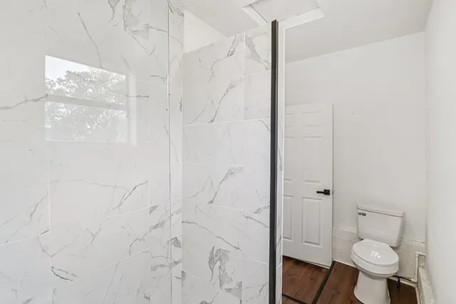 a bathroom with a toilet and a shower