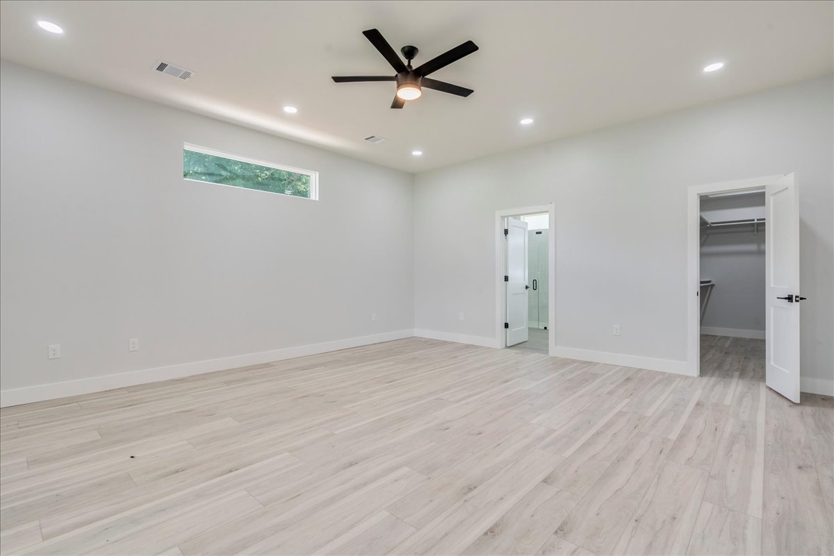 1215 Howard Street Taylor, TX 76574 - Photo 12 of 37 an empty room with wooden floor and a ceiling fan