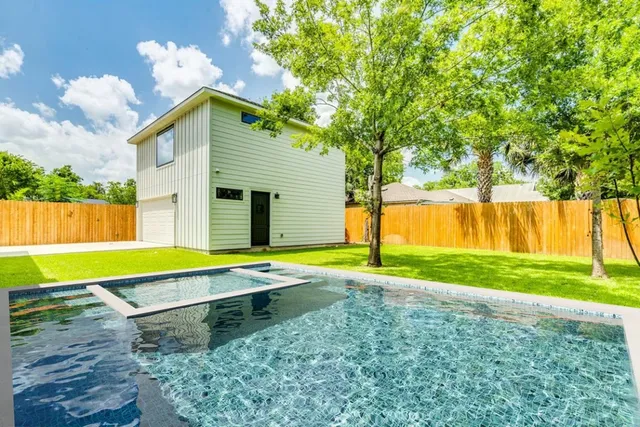 a front view of a house with yard and tree