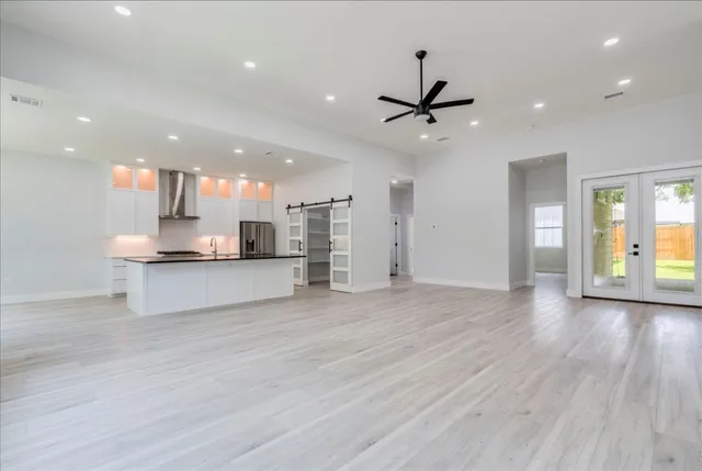 a view of kitchen with kitchen island wooden floor center island and stainless steel appliances