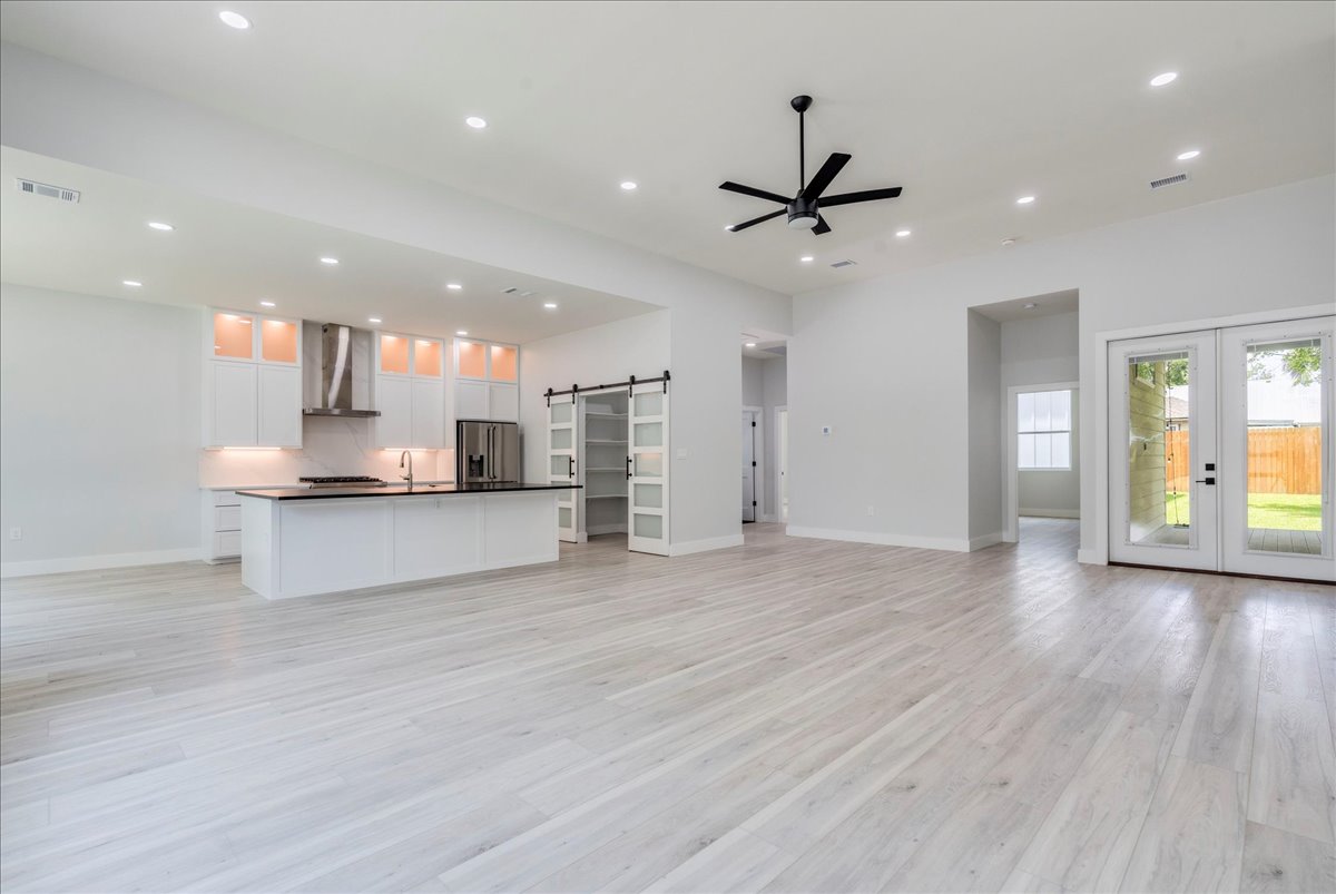 1215 Howard Street Taylor, TX 76574 - Photo 4 of 37 a view of kitchen with kitchen island wooden floor center island and stainless steel appliances
