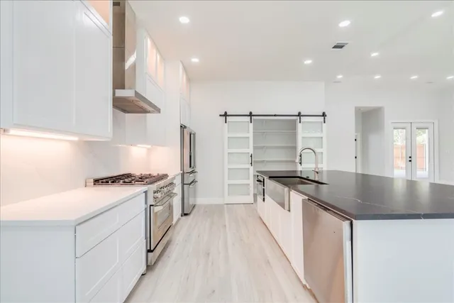 a kitchen with stainless steel appliances granite countertop a stove a sink and a refrigerator