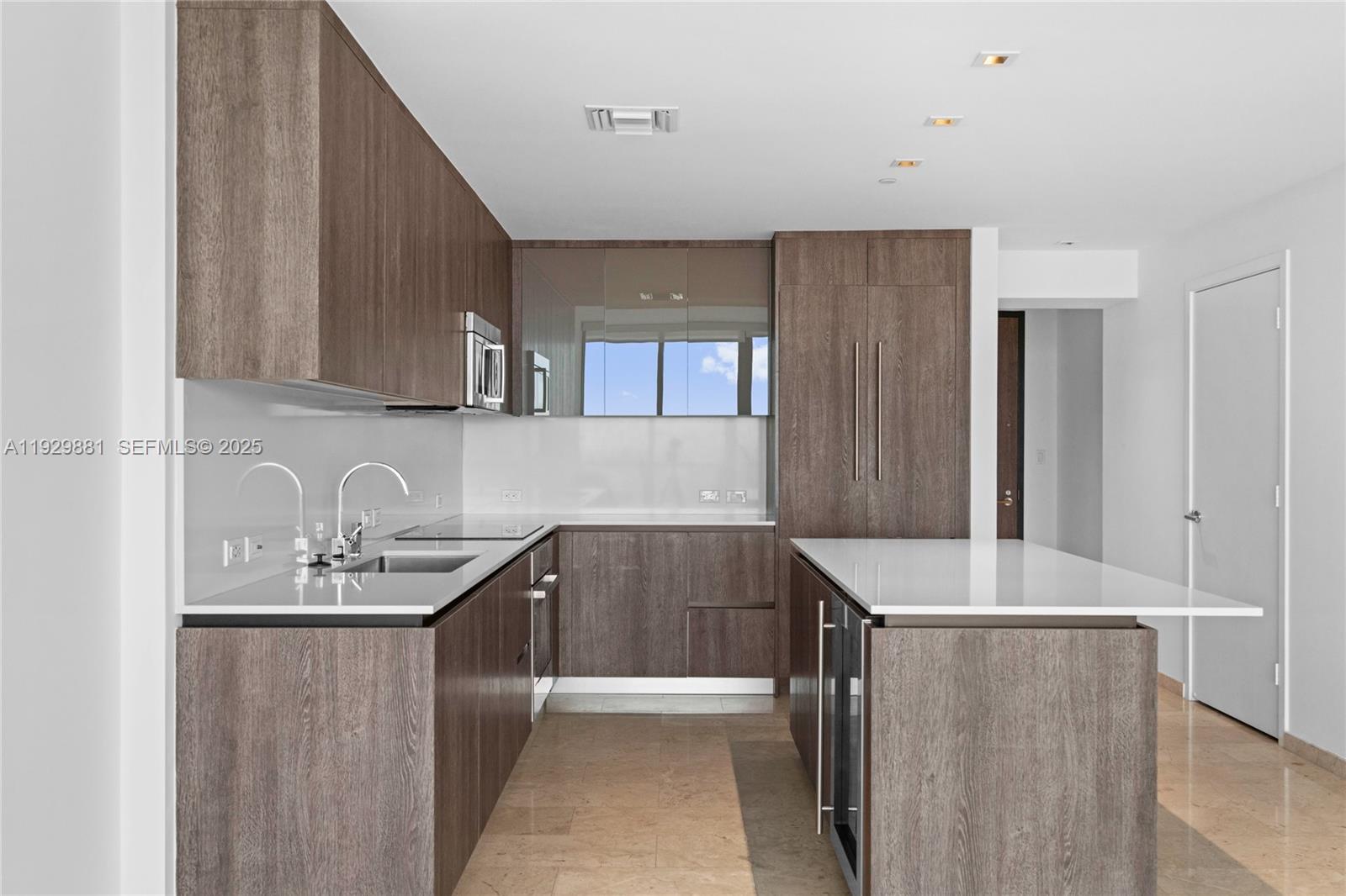 88 Southwest 7th Street, Unit 3608 Miami, FL 33130 - Photo 26 of 36 a kitchen with kitchen island granite countertop a sink and refrigerator