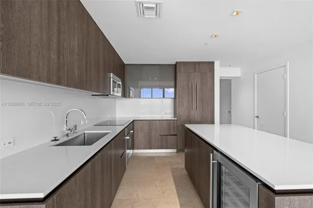 a kitchen with a sink a counter top space and cabinets