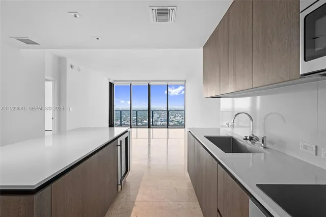 a kitchen with white cabinets a sink and dishwasher