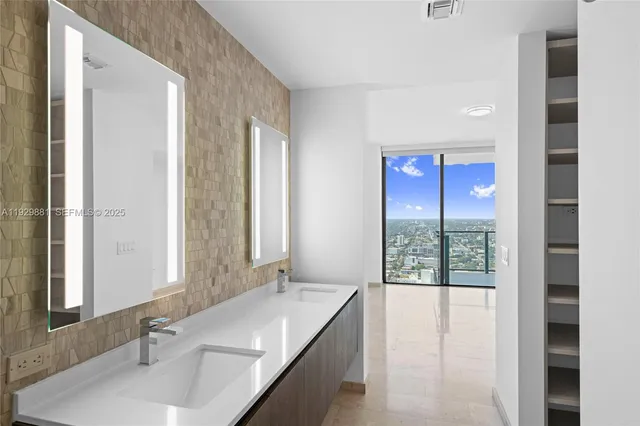 a bathroom with a granite countertop sink and a large mirror