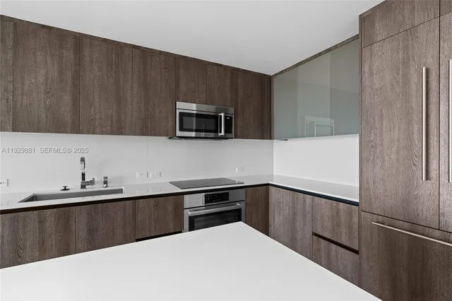 a kitchen with stainless steel appliances granite countertop a stove a sink and a microwave