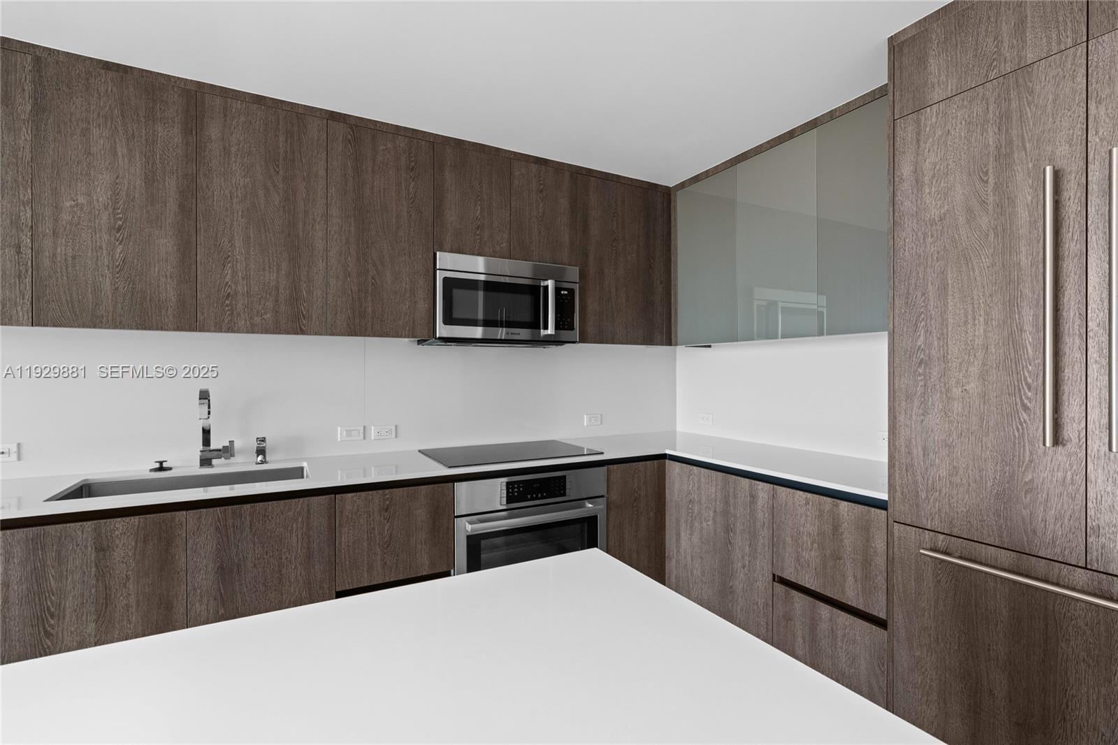 88 Southwest 7th Street, Unit 3608 Miami, FL 33130 - Photo 34 of 36 a kitchen with a sink a microwave and cabinets