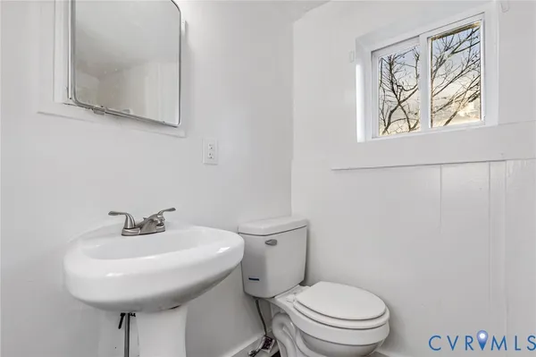 a bathroom with a toilet a sink and a mirror