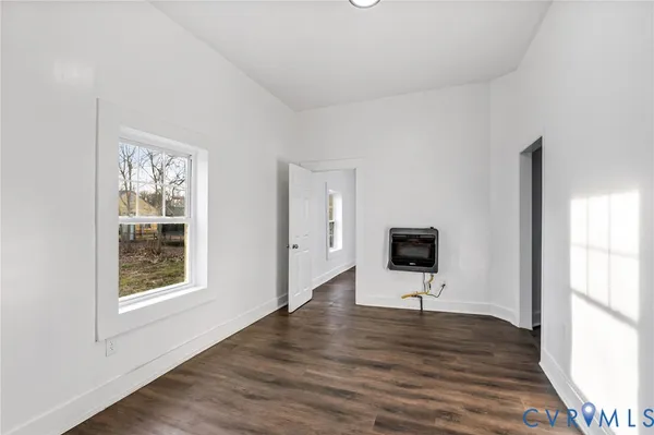 a view of a big room with wooden floor and windows