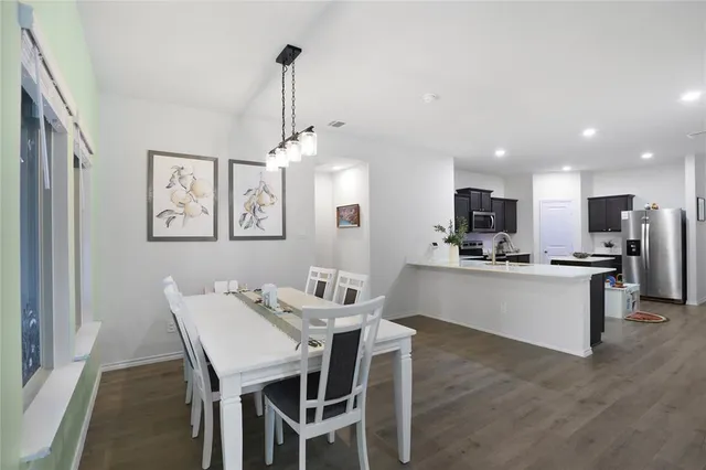 a large kitchen with a table and chairs