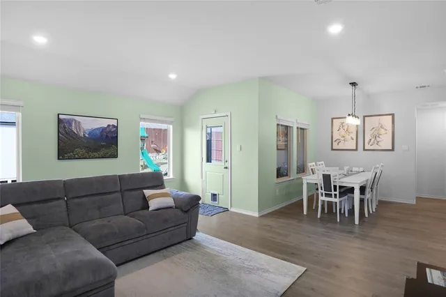a living room with furniture a dining table and wooden floor