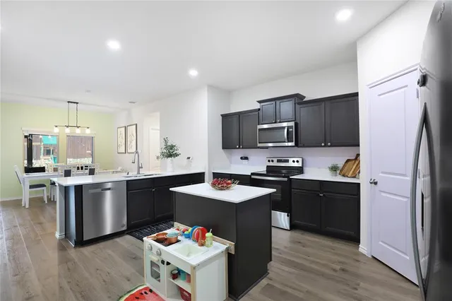 a kitchen with granite countertop stainless steel appliances sink stove microwave and cabinets