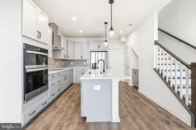 a kitchen with stainless steel appliances a stove a sink and a refrigerator