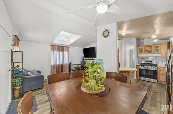 a living room with furniture kitchen and a flat screen tv