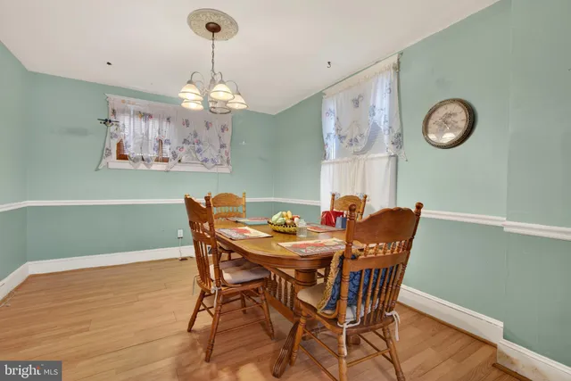 a view of a dining room with furniture a chandelier and wooden floor