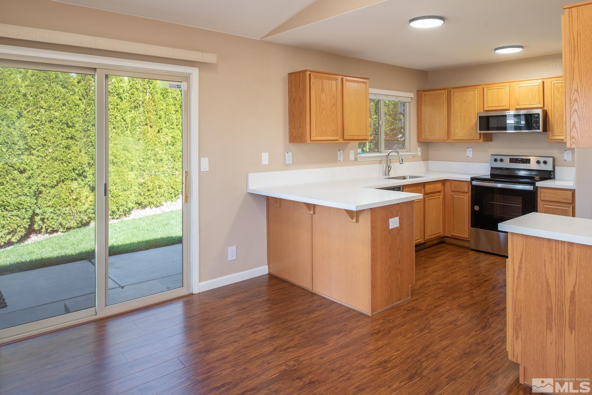 923 Ranchview Circle Carson City, NV 89705 - Photo 11 of 27 a kitchen with kitchen island granite countertop a stove top oven a sink and wooden floors