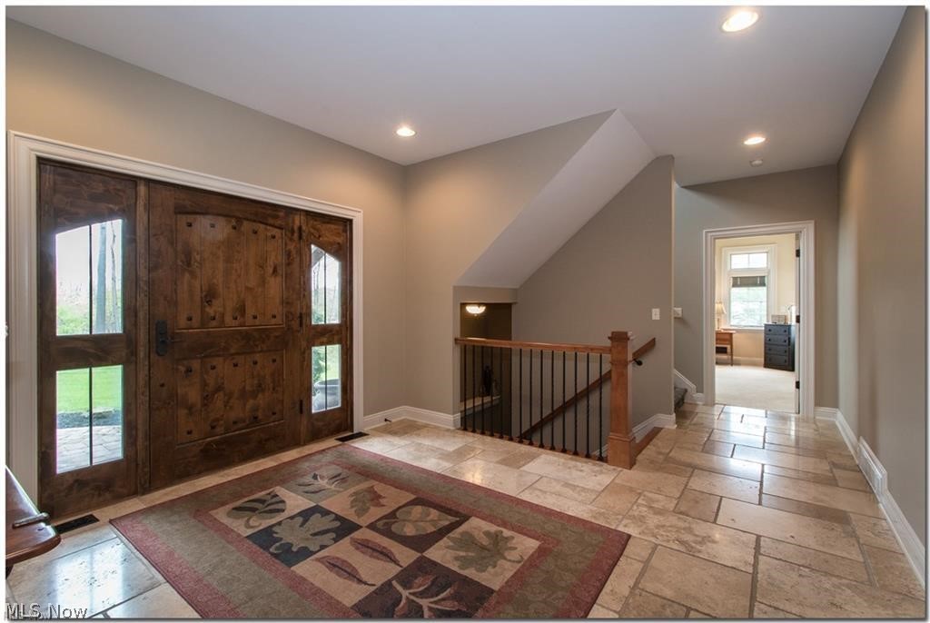 12430 Falcon Ridge Road Chesterland, OH 44026 - Photo 3 of 28 Stately solid wood entry door and travertine tile make this home astonishing! The oversized ADA approvable hall ways and doorways with no elevation on the main floor, and first floor master suite give you one floor living at it's best!