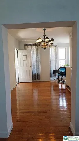 a view of a room with wooden floor and lounge chair