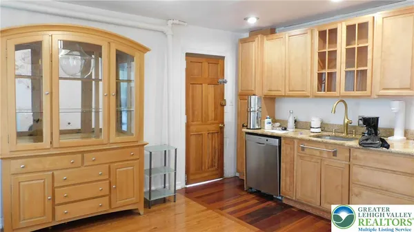 a kitchen with stainless steel appliances granite countertop a sink a stove and a wooden floors