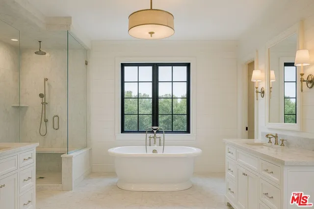 a bathroom with a bathtub a sink and a large mirror