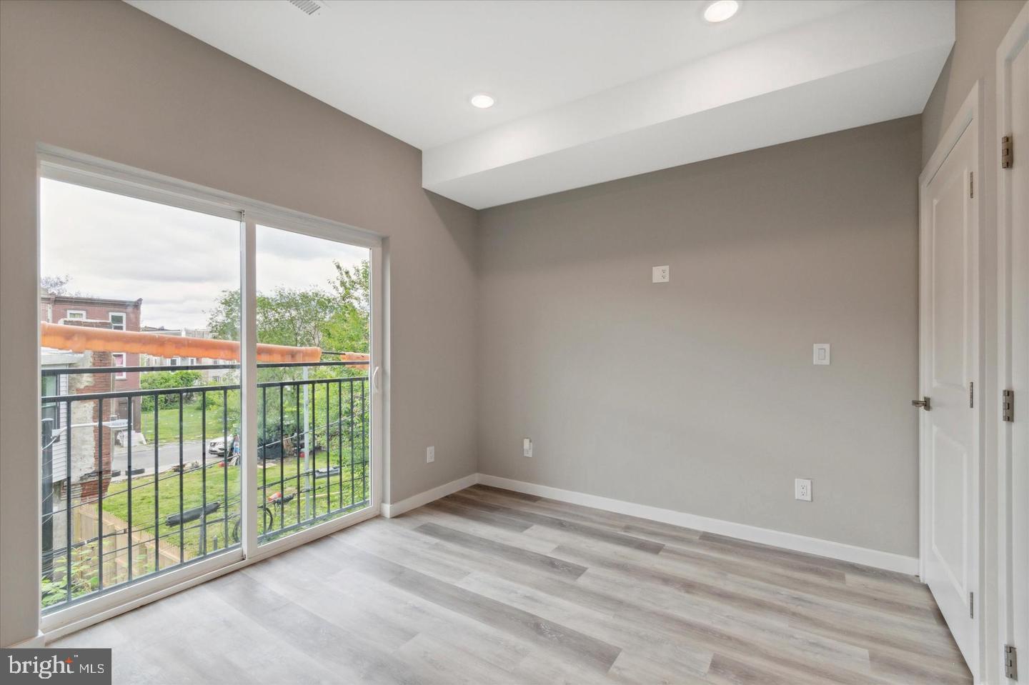 2424 Nicholas Street Philadelphia, PA 19121 - Photo 4 of 18 an empty room with wooden floor and windows