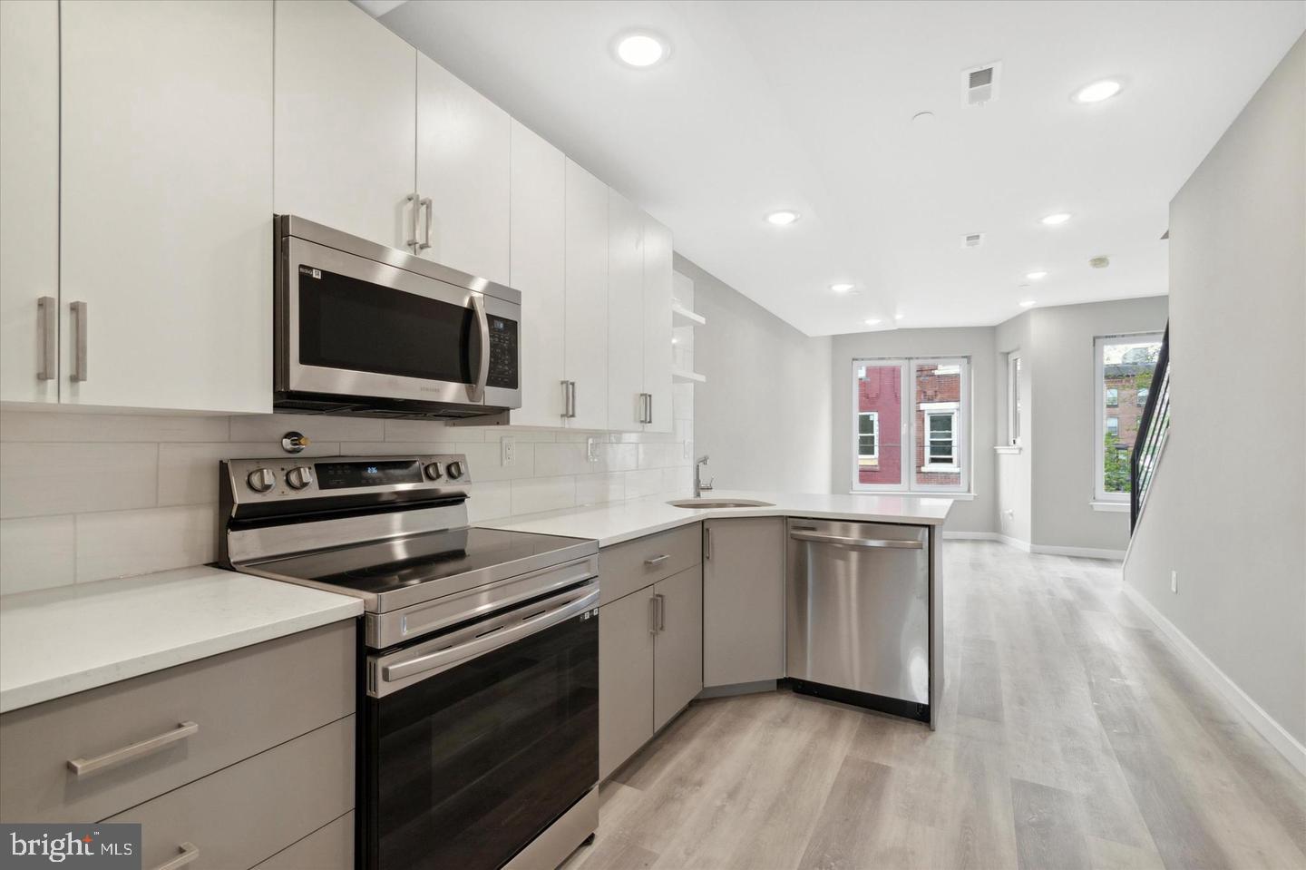 2424 Nicholas Street Philadelphia, PA 19121 - Photo 10 of 18 a kitchen with stainless steel appliances a stove sink microwave and cabinets