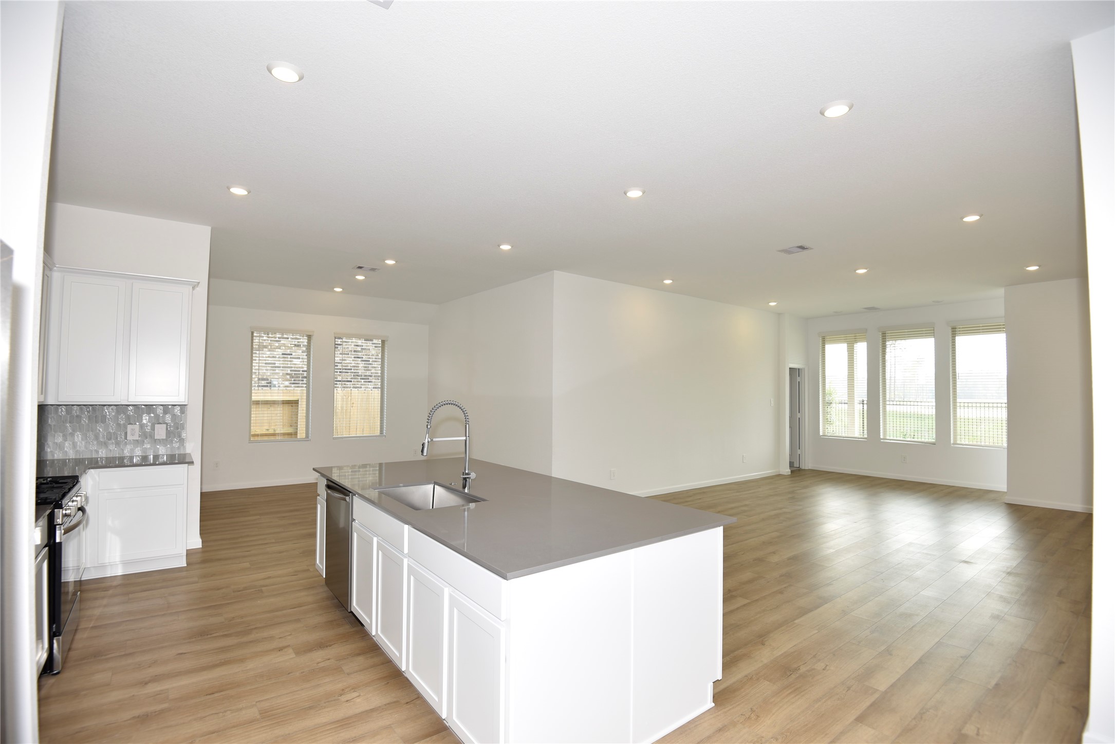 15524 Leopard Lily Lane Conroe, TX 77302 - Photo 11 of 47 a kitchen with a sink and wooden floor