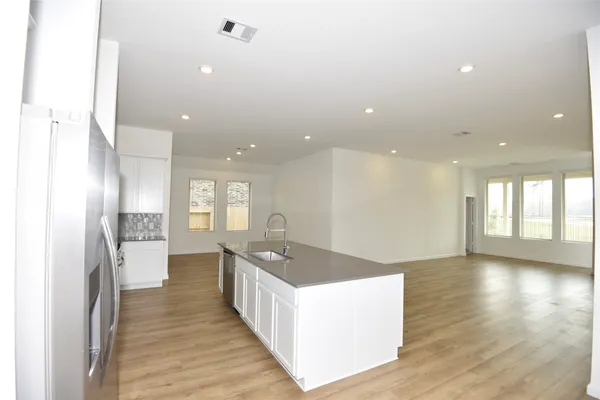 a open kitchen with stainless steel appliances granite countertop a refrigerator and a sink