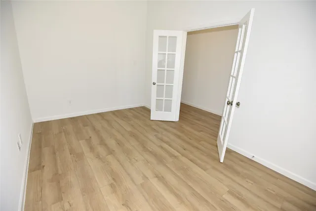an empty room with wooden floor and closet