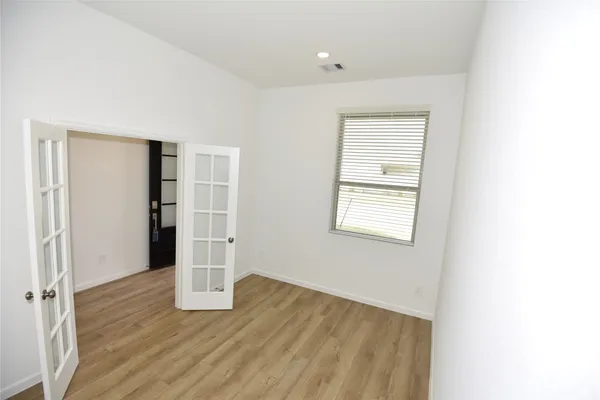 a view of empty room with wooden floor